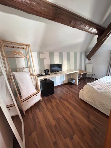 a bedroom with a bed and a desk with a television at La Magnolia - House in Verona