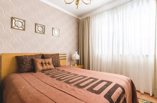 a bedroom with a large bed and a window at Near beach and Oporto in Vila Nova de Gaia