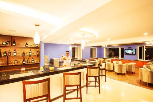 a man standing at a bar in a restaurant at Sterling Ooty Fern Hill in Ooty
