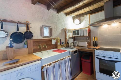 a kitchen with a sink and a stove top oven at L'atelier du huchier in Poucharramet