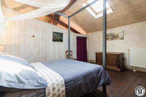 a bedroom with a bed in a room with a ceiling at L'atelier du huchier in Poucharramet
