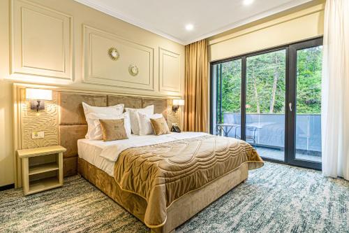a bedroom with a bed and a large window at Davo Hotel in Târgu Neamț