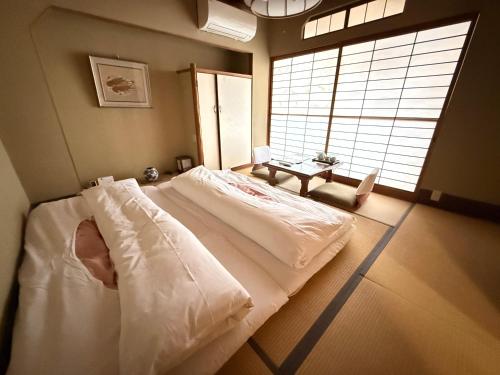 a large bed in a room with a large window at Tazuru in Kyoto