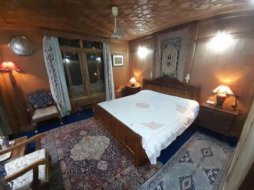 a bedroom with a bed and two tables and chairs at Jackson Heights Houseboats in Srinagar