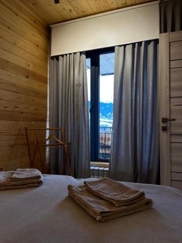 a bedroom with a bed with a large window at Kainar Glamp Домик в горах с террасой и прекрасным видом на горы in Besqaynar