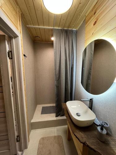 a bathroom with a sink and a shower with a mirror at Kainar Glamp Домик в горах с террасой и прекрасным видом на горы in Besqaynar
