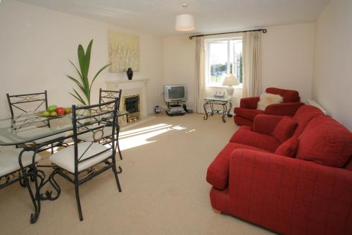 a living room with a red couch and a table at Orchard Gate Apartments from Your Stay Bristol in Bristol