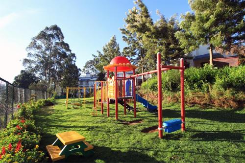 park z placem zabaw w trawie w obiekcie Sterling Ooty Fern Hill w mieście Utakamand