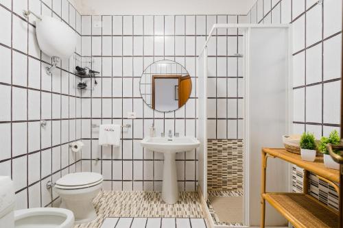 a white bathroom with a toilet and a sink at Casa Stella Otranto Centre - Sea View, AC & WiFi in Otranto