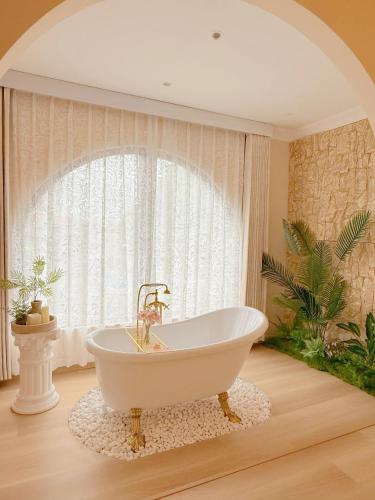 a bath tub in a bathroom with a window at The Cozy Cottage Semporna in Semporna