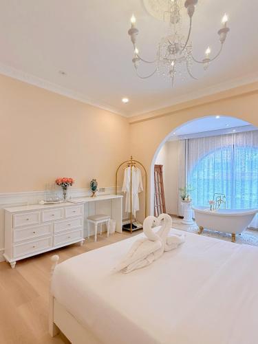 a bedroom with a bed with two swans on it at The Cozy Cottage Semporna in Semporna
