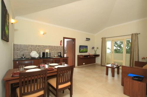 a kitchen and dining room with a table and chairs at Sterling Ooty Fern Hill in Ooty