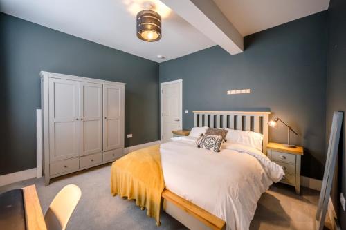 a bedroom with a large bed with blue walls at The Leiston, Valley Road in Leiston