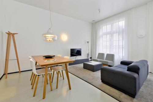 a living room with a table and a couch at Urban Residences Maastricht in Maastricht