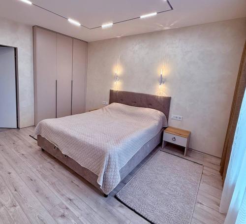 a bedroom with a large bed and a wooden floor at Центр стадіон Central Сity Замкова in Rivne