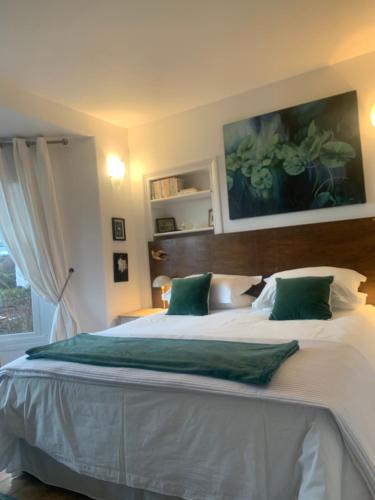 a bedroom with a large white bed with green pillows at Chy Sabona - Front Room in Penzance