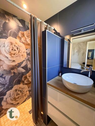 a bathroom with a sink and a flower wallpaper at Tranquiloue - Maison de Campagne - PuyduFou in Treize-Vents