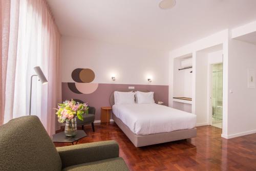 a hotel room with a bed and a couch at LSA Campos by Numa in Lisbon
