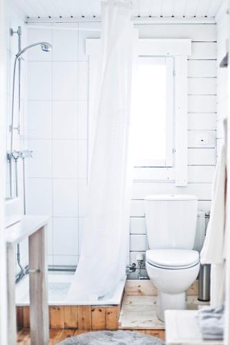ein weißes Badezimmer mit Toilette und Dusche in der Unterkunft Akurgerði Guesthouse 2 - Country Life Style in Ölfus