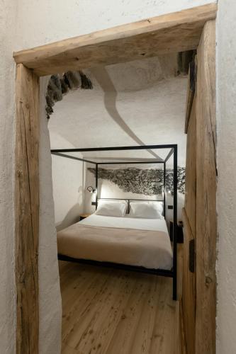 a bedroom with a bed with a black bed frame at Grotta Bàlzer in Valdidentro