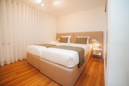a bedroom with a large white bed in a room at Magníficos Dias Atlânticos Studio in Moledo