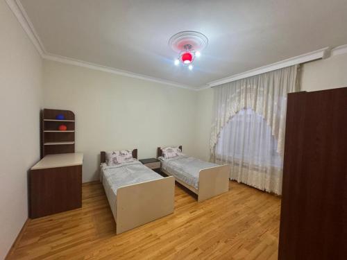 ein Zimmer mit zwei Betten und einem Fenster in der Unterkunft Ümid Əmlak in Quba