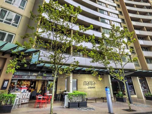 a apartment building with a cafe in front of it at Mantra Chatswood in Sydney
