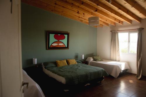 a bedroom with two beds and a window at Hosteria Casa kuyen in El Calafate