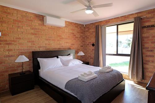 a bedroom with a bed and a brick wall at Pamusha 2 in Geraldton