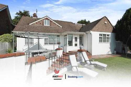 a white house with a patio with chairs and tables at 4 Bedroom House By Guest Nest Management Vacation Rental Brighton With Hot Tub & Pet Friendly in Brighton & Hove