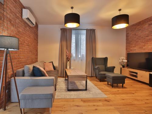 a living room with a couch and chairs and a tv at Dworek Brzozowy, Augustów Płaska in Płaska