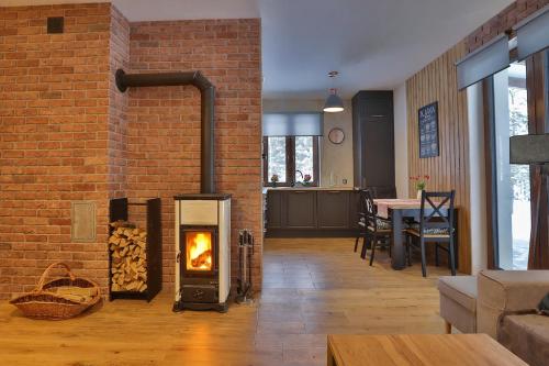 a living room with a brick wall and a fireplace at Dworek Brzozowy, Augustów Płaska in Płaska