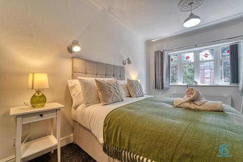 a bedroom with a bed with a stuffed dog sitting on it at 4 Bedrooms- Sleeps 8 in Kidderminster