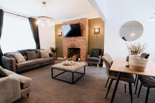 a living room with a couch and a fireplace at Meldon Cottage with Private Hot Tub in Newbiggin-by-the-Sea