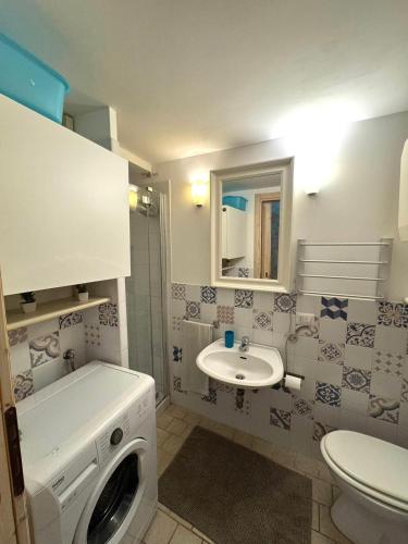 a bathroom with a washing machine and a sink at La torretta del SUD in Bisceglie