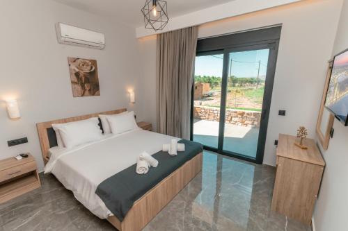 a bedroom with a large bed and a balcony at Aurora 3 - Family Comfort near the beach in Marmari