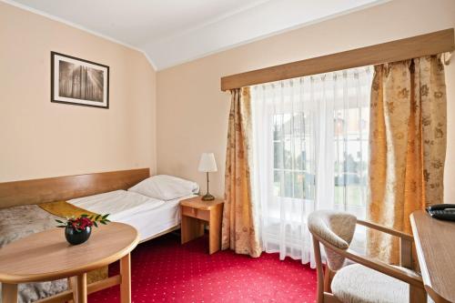 a hotel room with a bed and a window at Hotel Karczyce in Karczyce