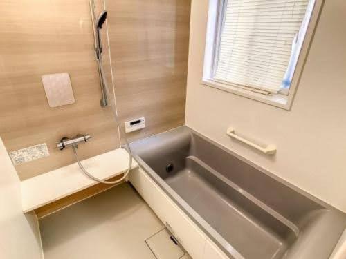 ein Badezimmer mit Waschbecken, Badewanne und Fenster in der Unterkunft Seminare in Karuizawa