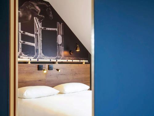 a bedroom with two white pillows on a bed at ibis Styles Saumur Gare Centre in Saumur