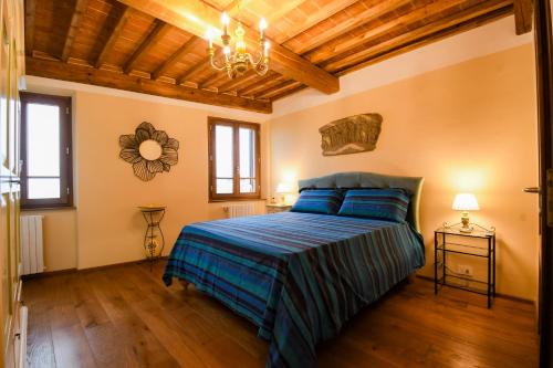 a bedroom with a bed with a blue comforter at Prugnolo Grand View in Montepulciano