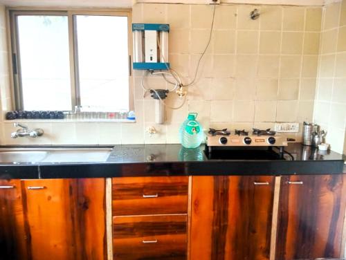 a kitchen with a black counter top and a stove at Dwarka By Natures Sweet Homes in Panchgani