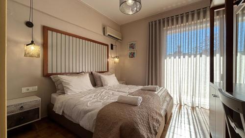 a bedroom with a bed with a large window at Hotel Pitsakis in Tolo