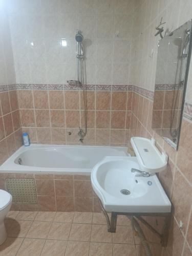 a bathroom with a tub and a sink and a toilet at Chambre aménagée dans un hôtel in Douala