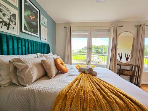 a bedroom with a large bed with a green headboard at Modern 5 Bedroom Townhouse with Free Parking in Glasgow