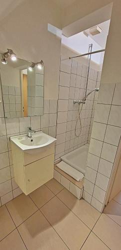 a bathroom with a sink and a shower and a tub at Le Relais - Appart'Hotel in Düsseldorf