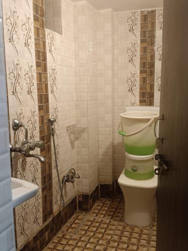 a bathroom with a green toilet and a sink at hotel atithi palace in Jabalpur