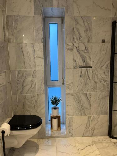 a bathroom with a toilet and a window at Modern & Central - Free Parking & Stylish Decor in Vossevangen