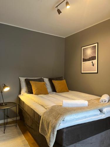 a bedroom with a large bed with yellow pillows at Modern & Central - Free Parking & Stylish Decor in Vossevangen