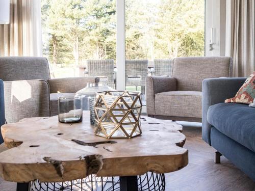 a living room with a wooden coffee table and chairs at Luxurious villa for 8 people in De Cocksdorp Texel in De Cocksdorp