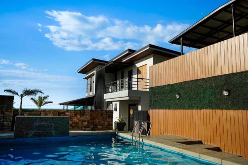 a house with a swimming pool next to a building at Elmarie Beach Resort in San Fabian